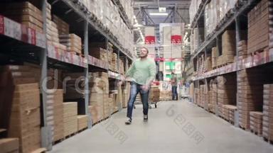 一个开朗的人对他的购物很高兴，他在仓库里的货架上蹦蹦跳跳